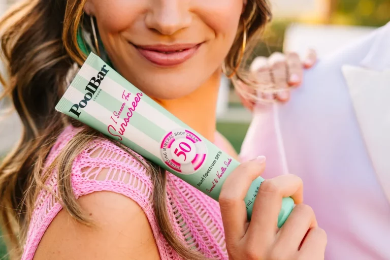 woman smiling holding spf50 sunscreen