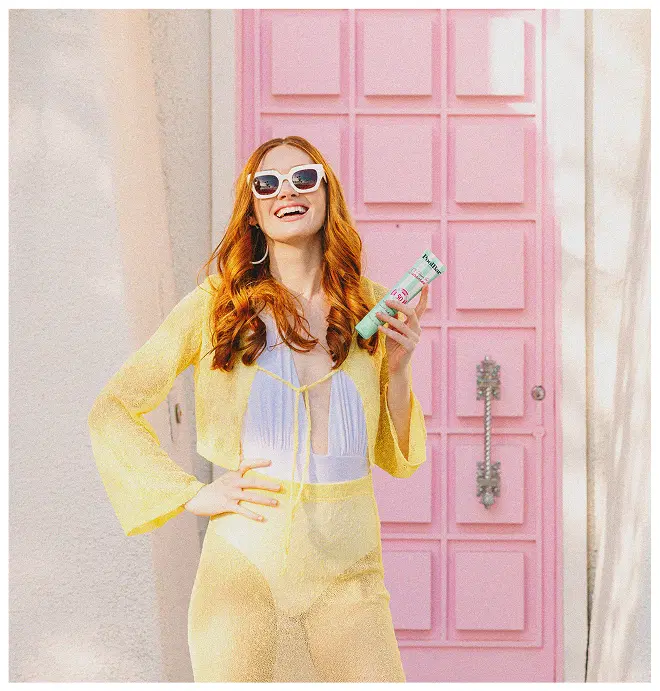 woman in yellow co ord holding i scream for sunscreen spf50