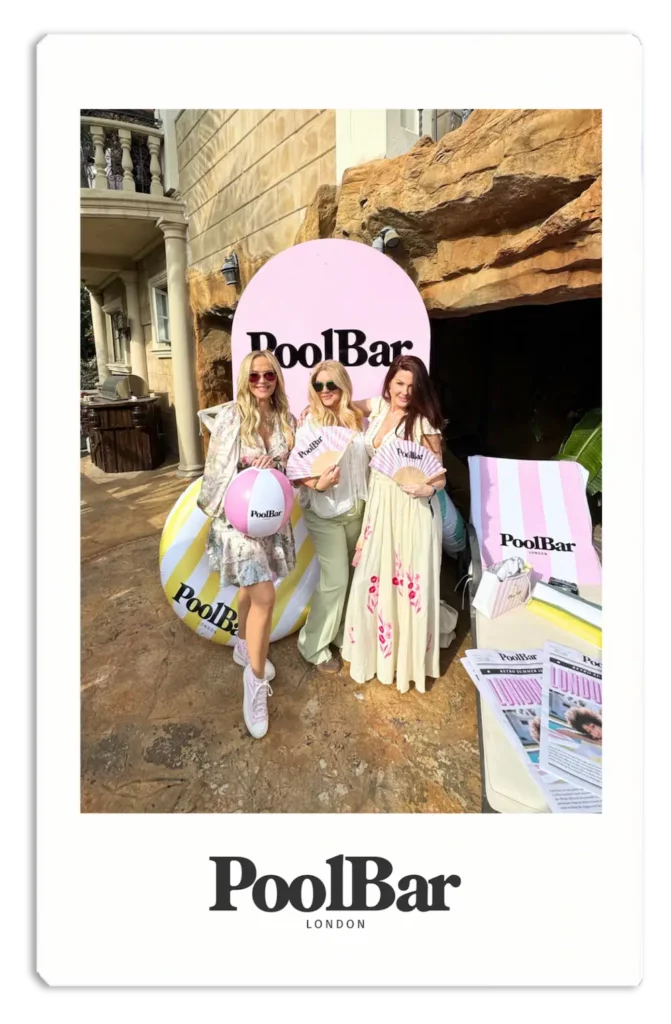 3 women smiling with poolbar fans and pink and white striped beach ball polaroid