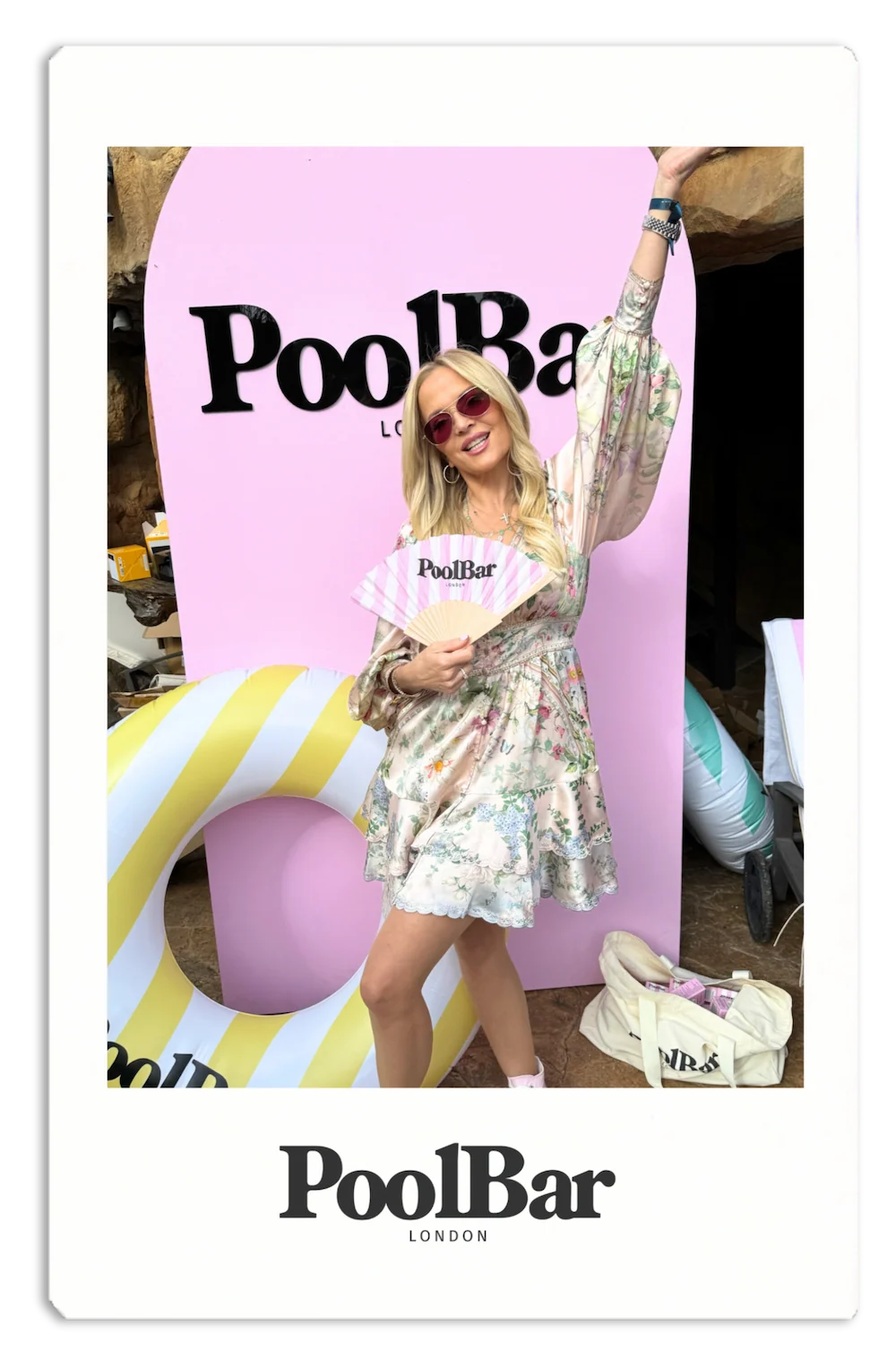 blonde woman holding fan and posing for picture with her arm up