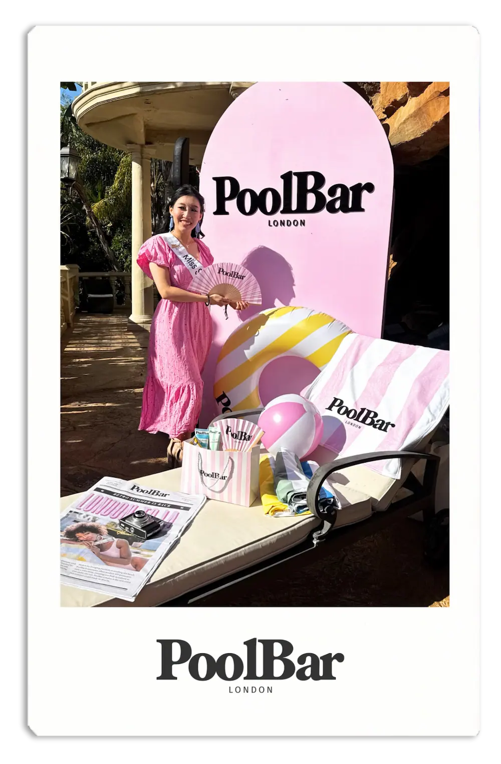 woman in pink dress holding fan and standing in front of poolbar beach merch