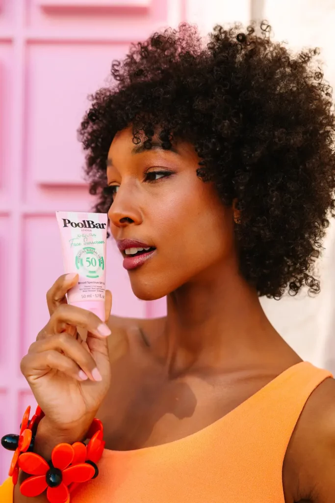 model posing and holding the poolbar spf 50 face sunscreen